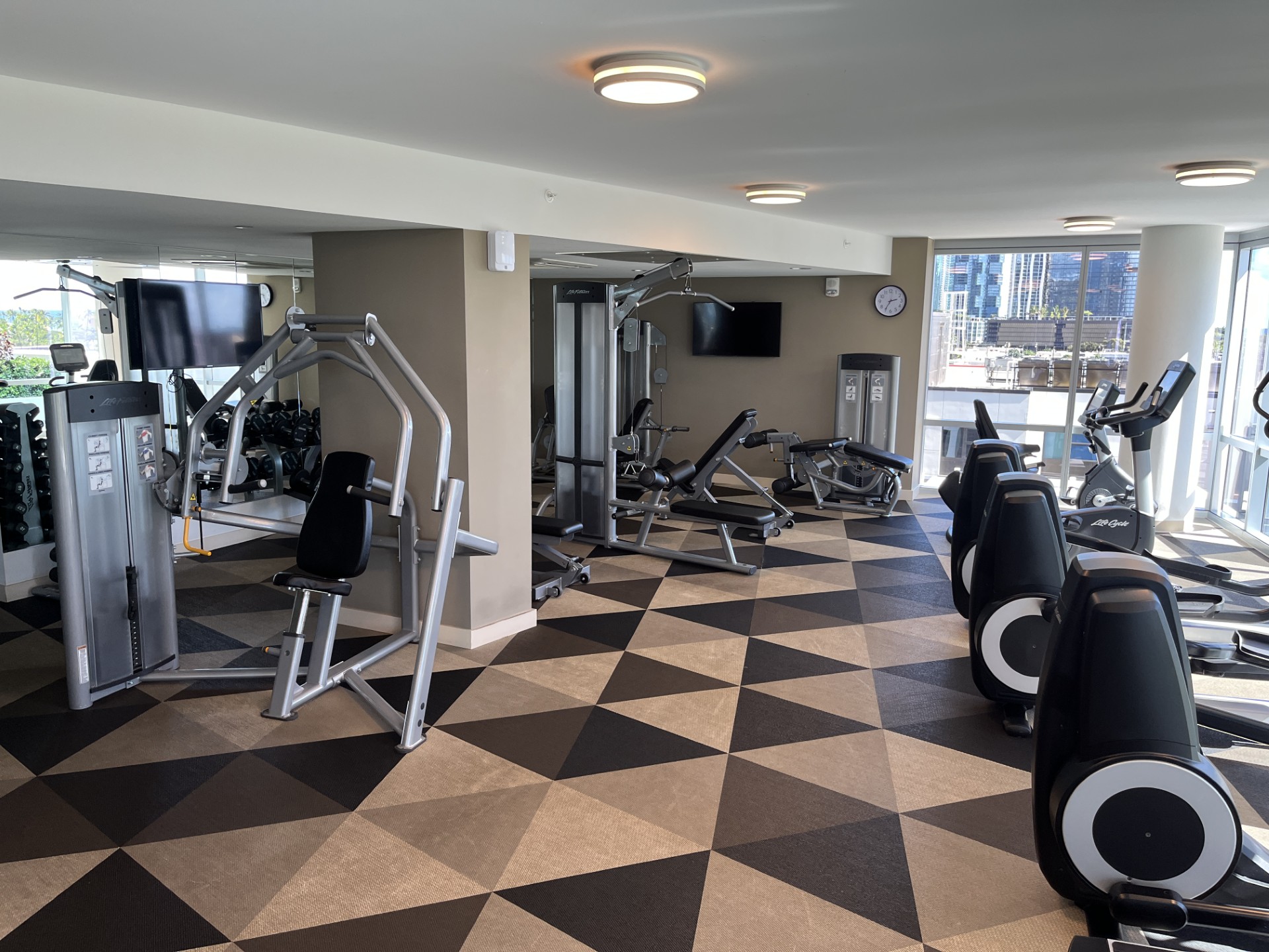 A gym with a variety of equipment including treadmills, weights, and exercise machines.